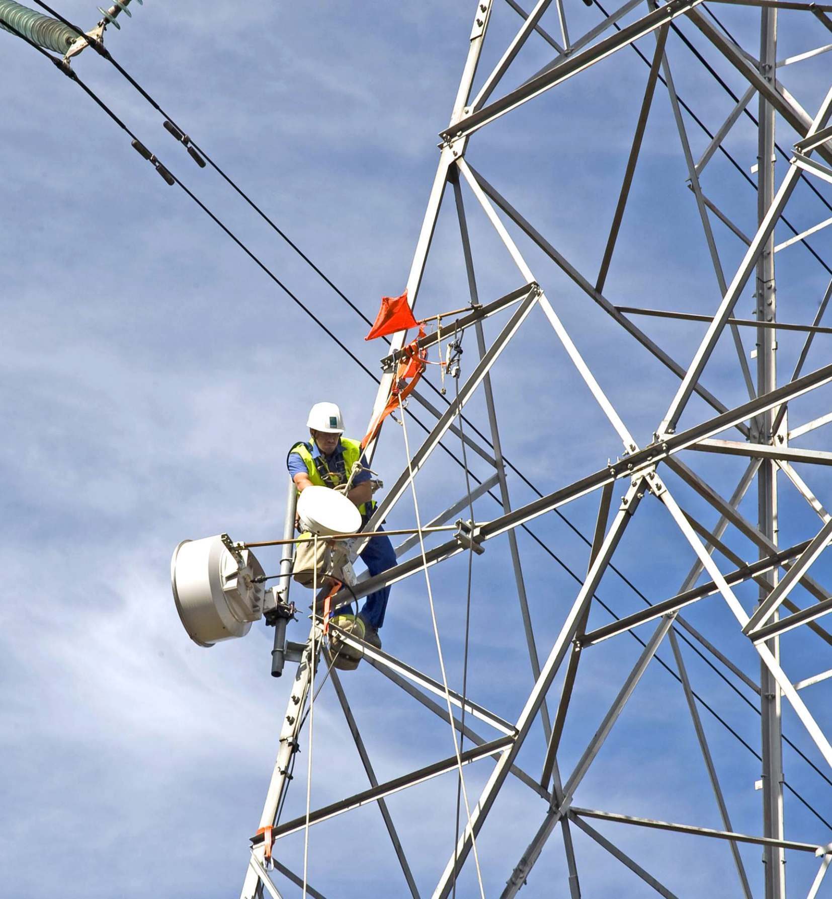 Técnico trabajando en una torre metálica de telecomunicaciones